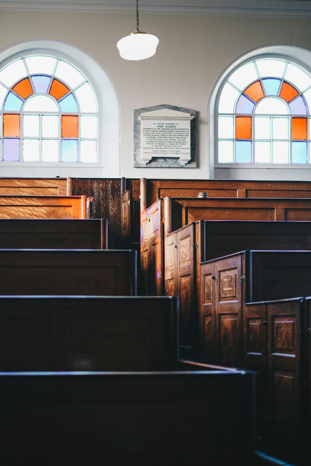 a church with stained glass windows and wooden pews