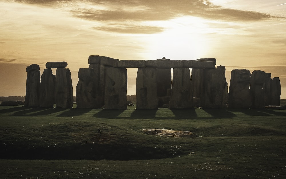 Ein Stonehenge auf einem Feld mit der untergehenden Sonne dahinter