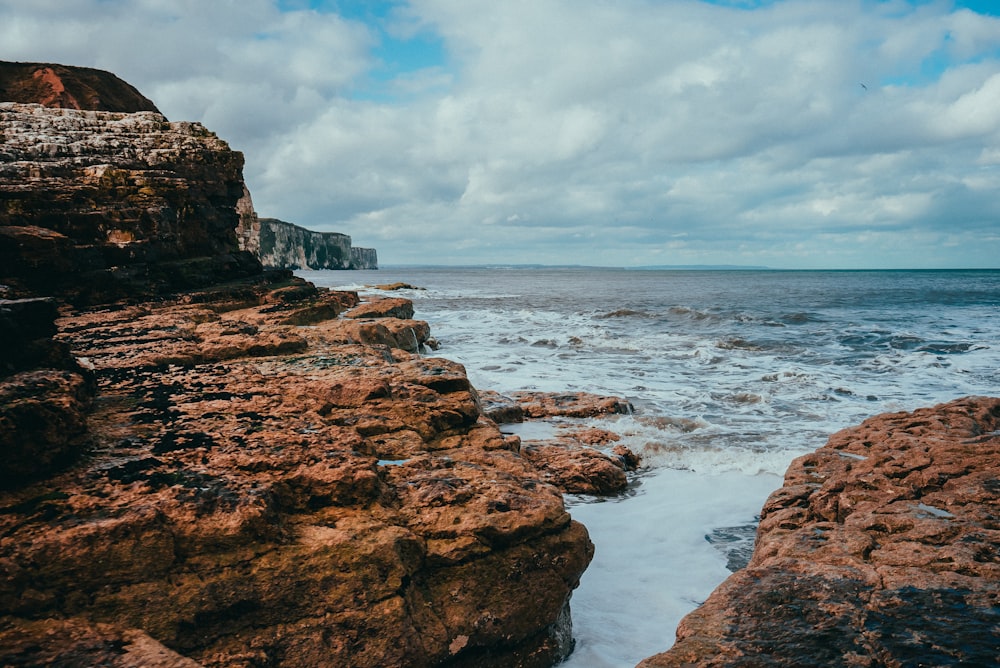 a rocky shore with waves crashing against the rocks