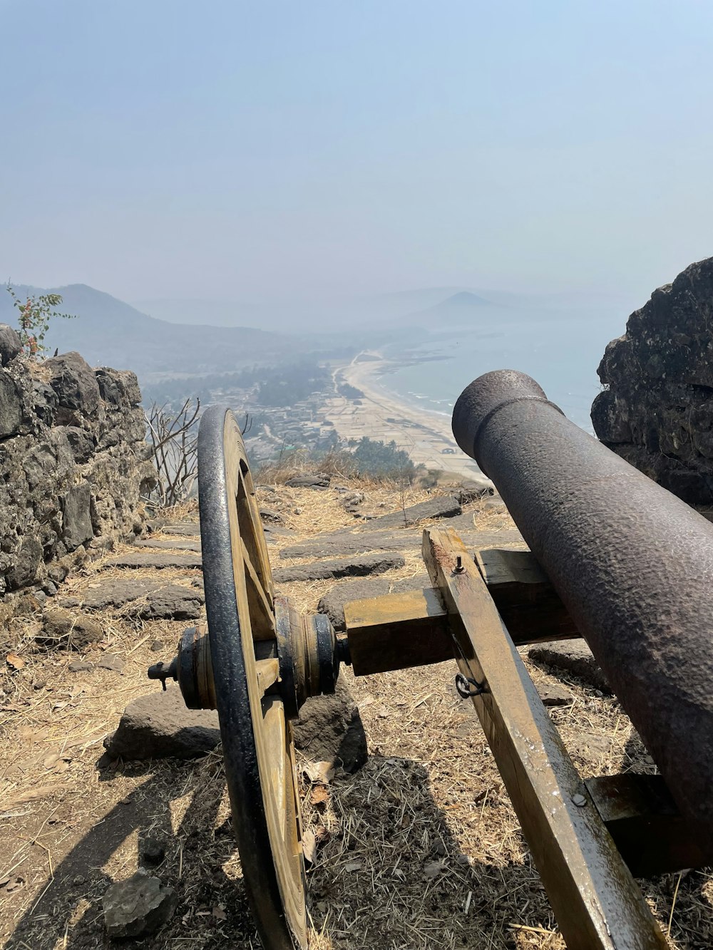 an old cannon on a hill with a view of the ocean