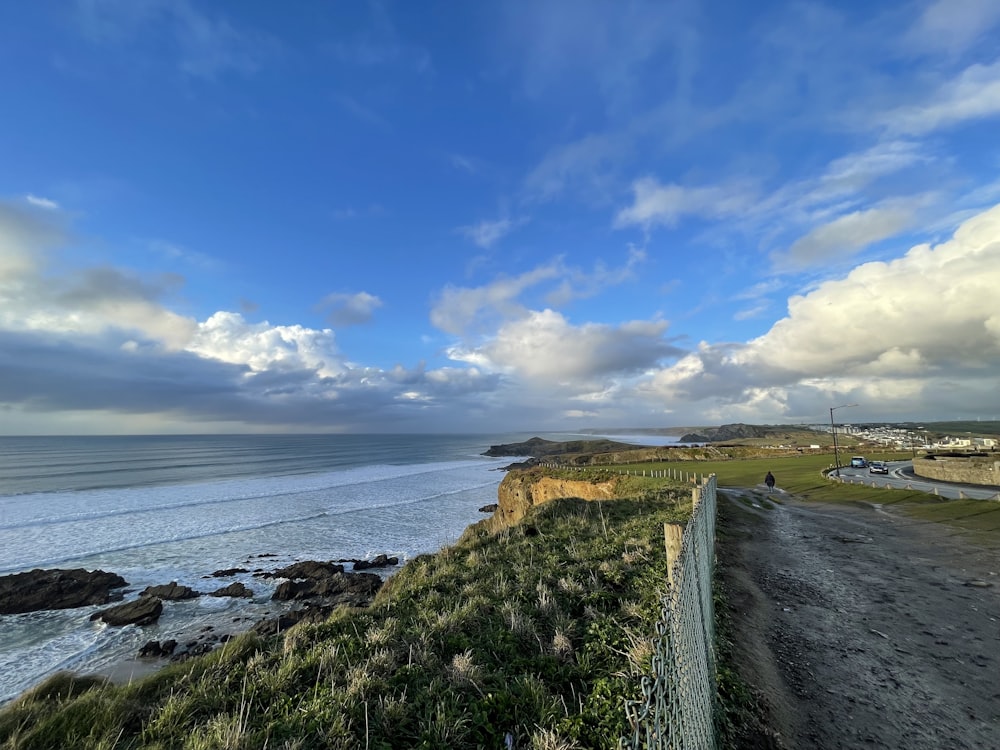 a person riding a bike on a path next to the ocean