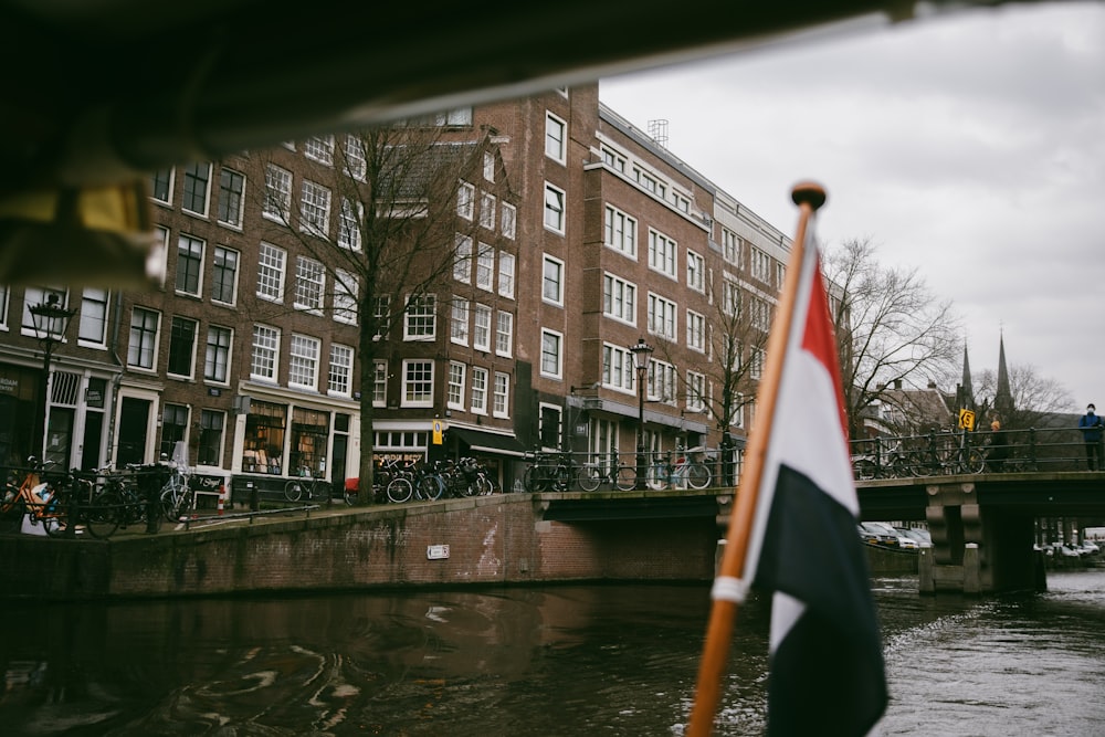 a flag on a pole next to a body of water