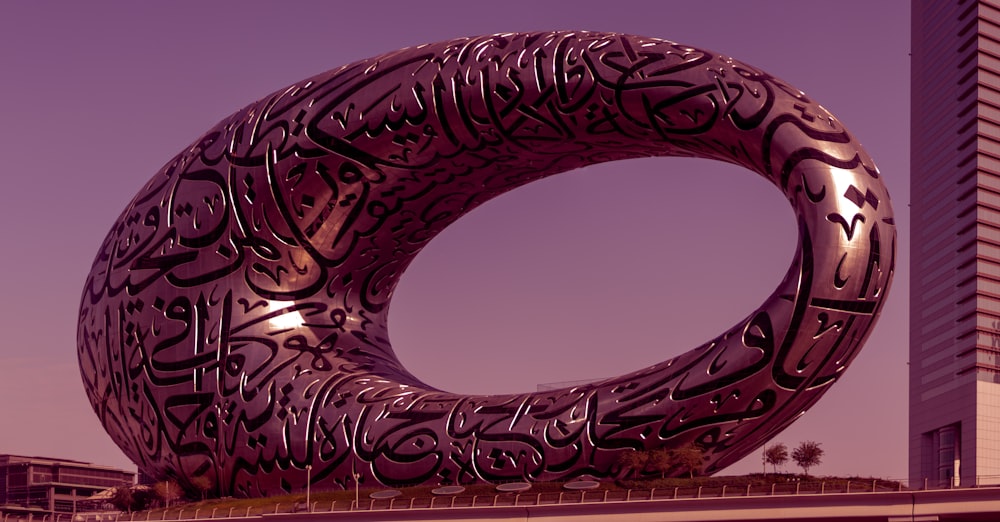 a large metal sculpture in front of a tall building