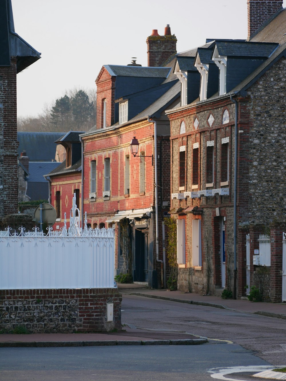 a row of brick buildings with a white picket fence in front of them
