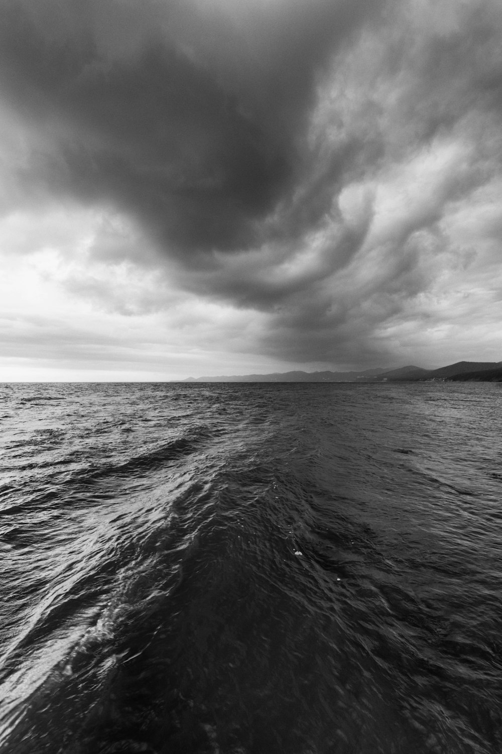 a black and white photo of a boat in the ocean