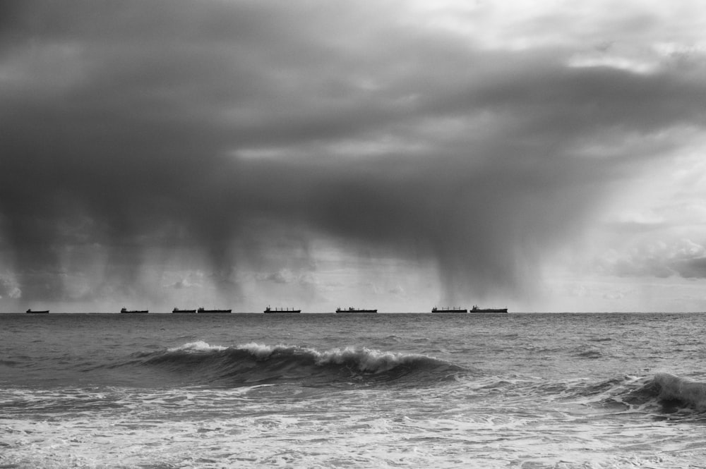 a black and white photo of a storm over the ocean