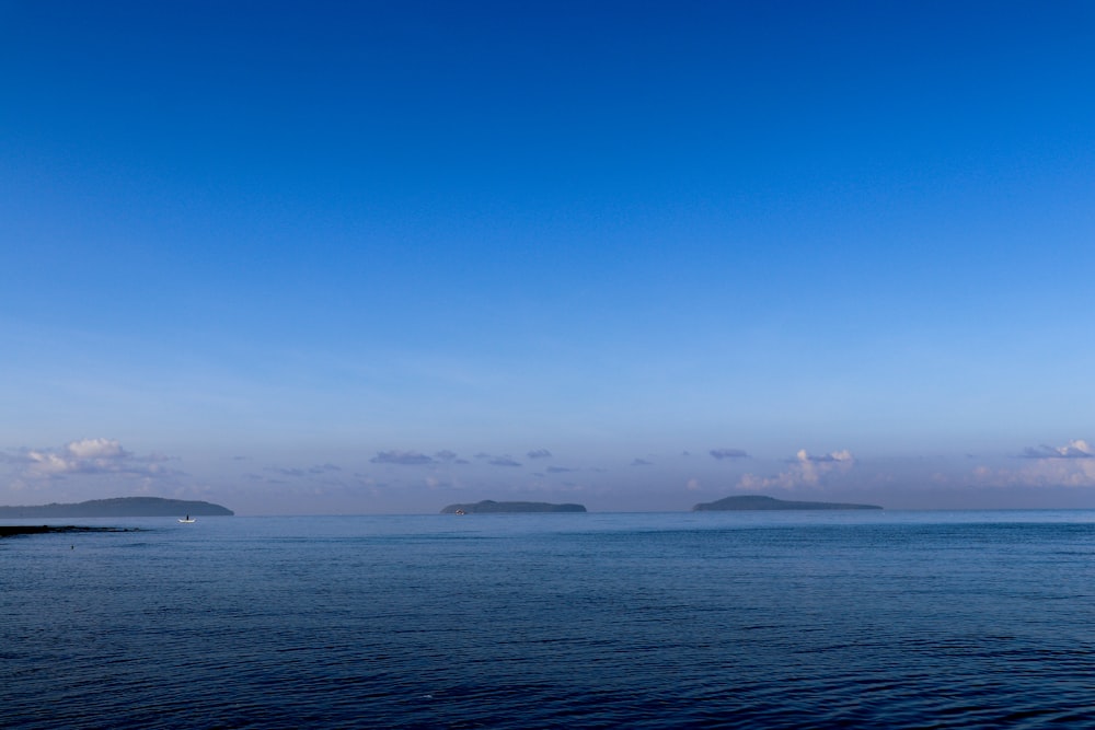 a large body of water with two small islands in the distance