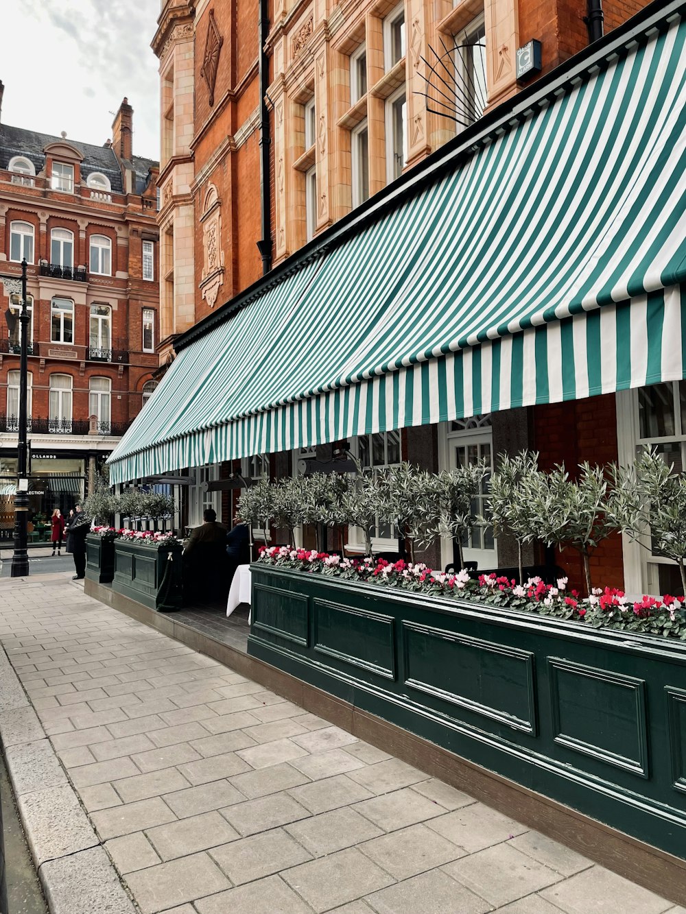 a green and white striped awning next to a building