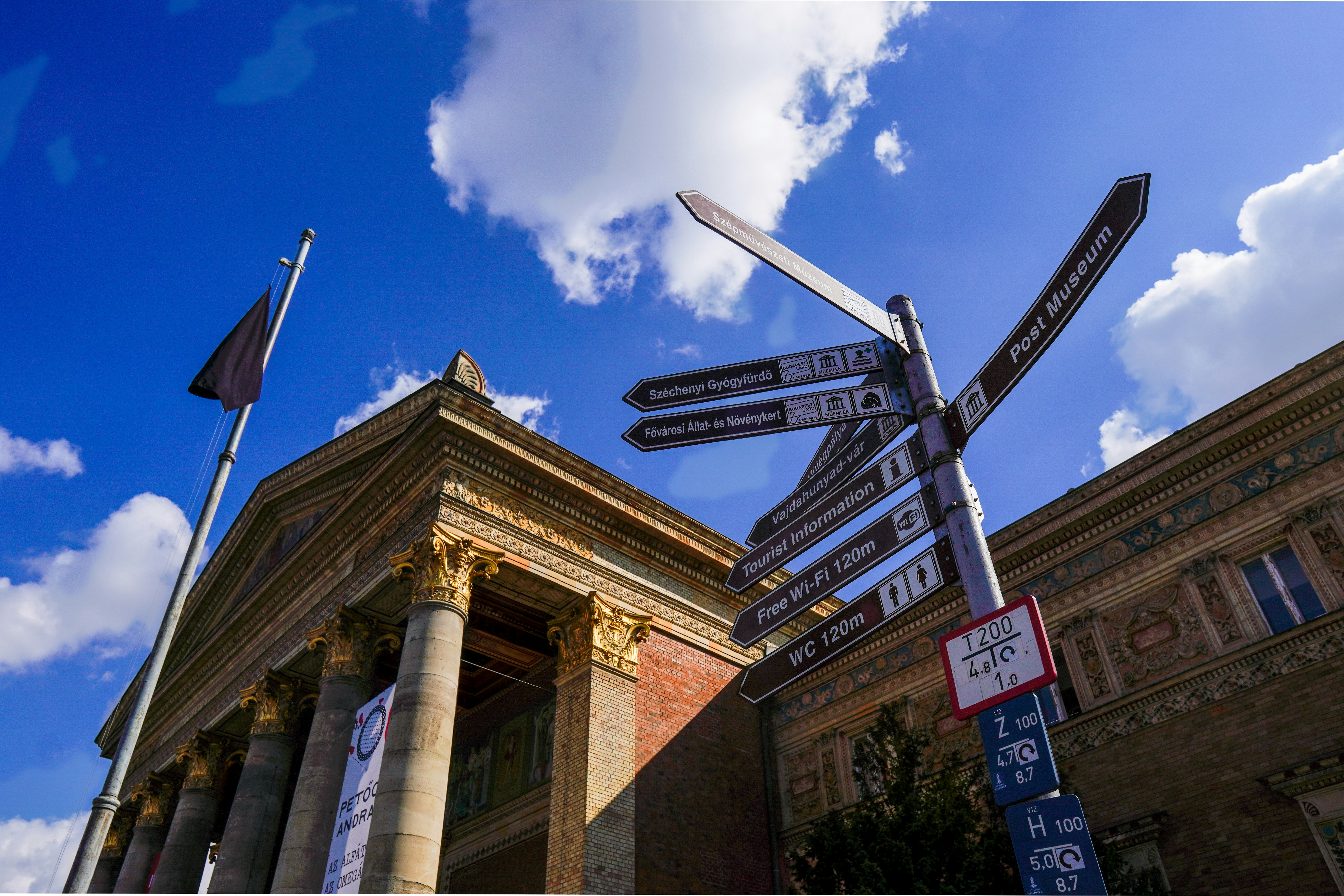 a bunch of street signs on a pole in front of a building