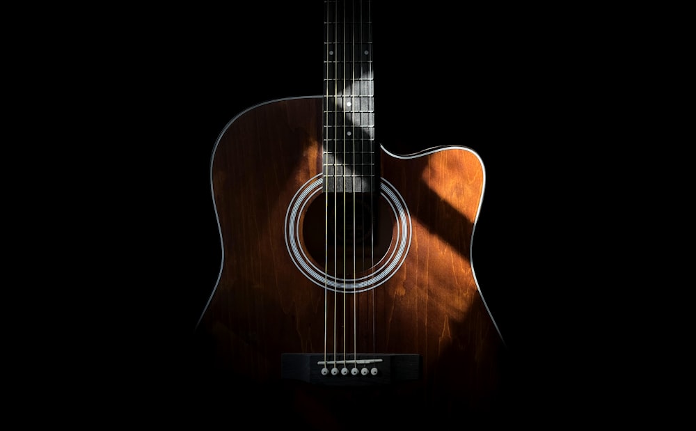 a close up of an acoustic guitar on a black background