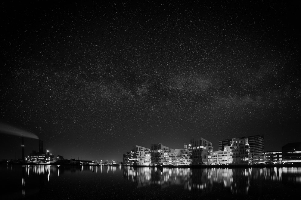 a night view of a city and its reflection in the water