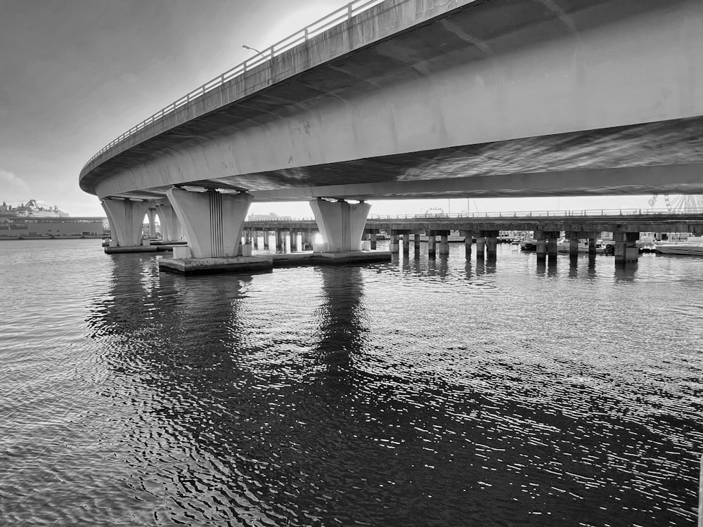 a black and white photo of a bridge over water