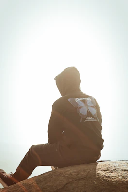Sunlit outdoor scene featuring a person relaxing in an elkora hoodie.