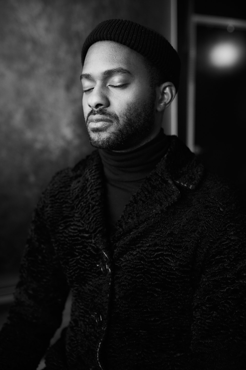 a black and white photo of a man with his eyes closed