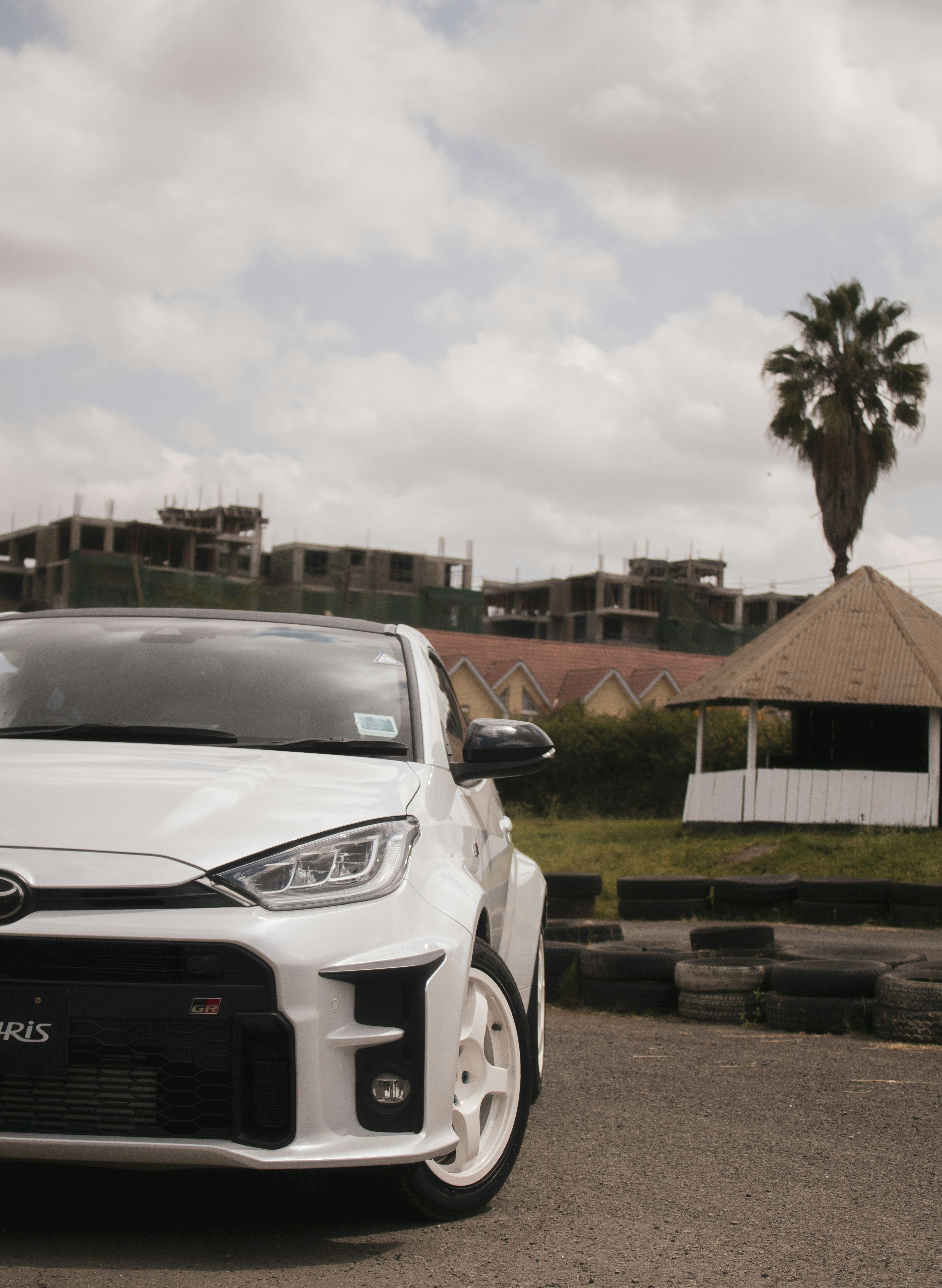 Sebuah mobil putih diparkir di pinggir jalan
