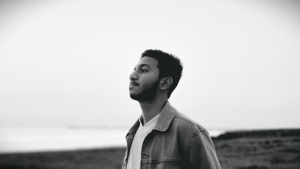 a black and white photo of a man looking off into the distance