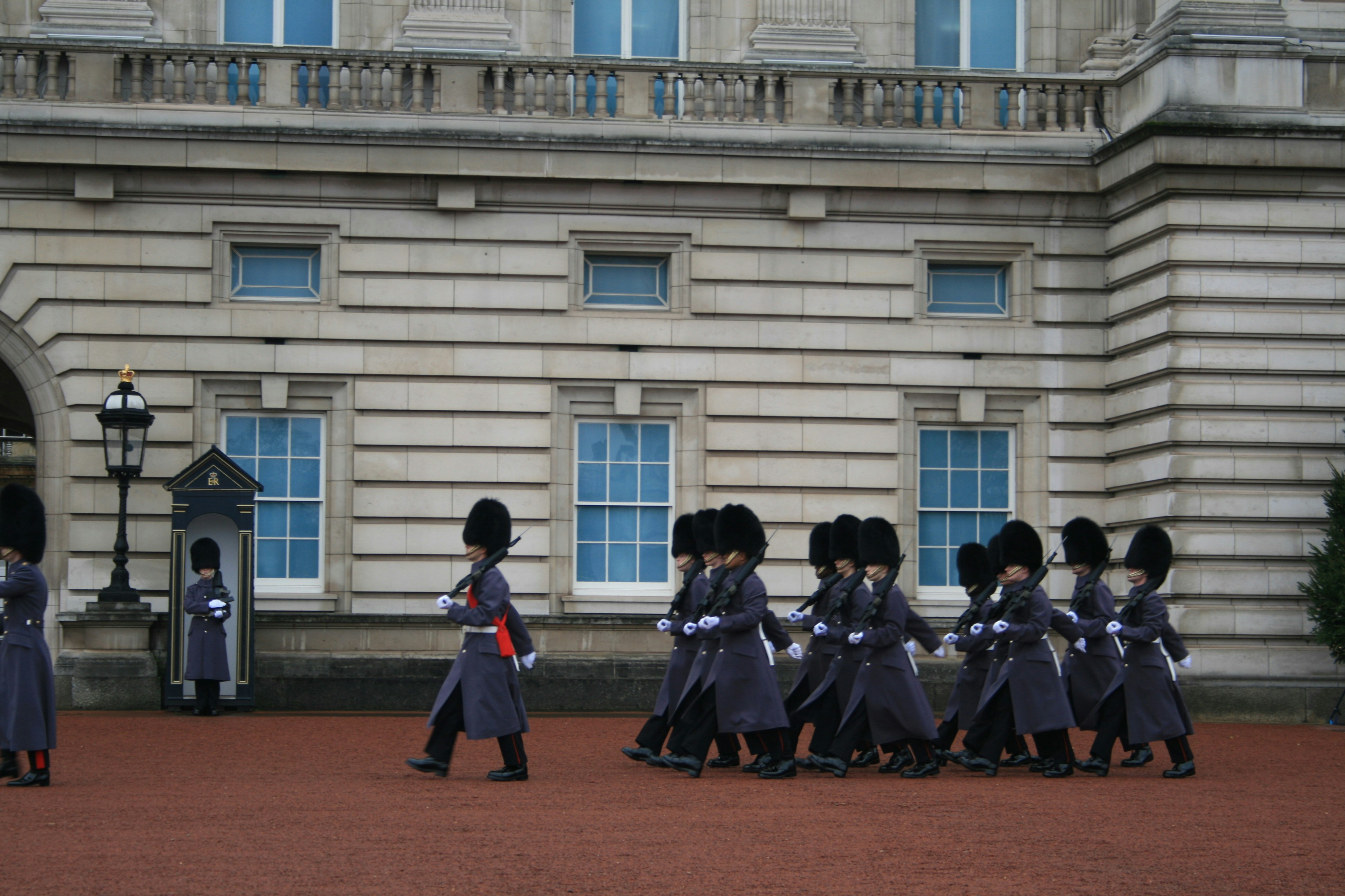 a group of men in uniform walking in front of a building