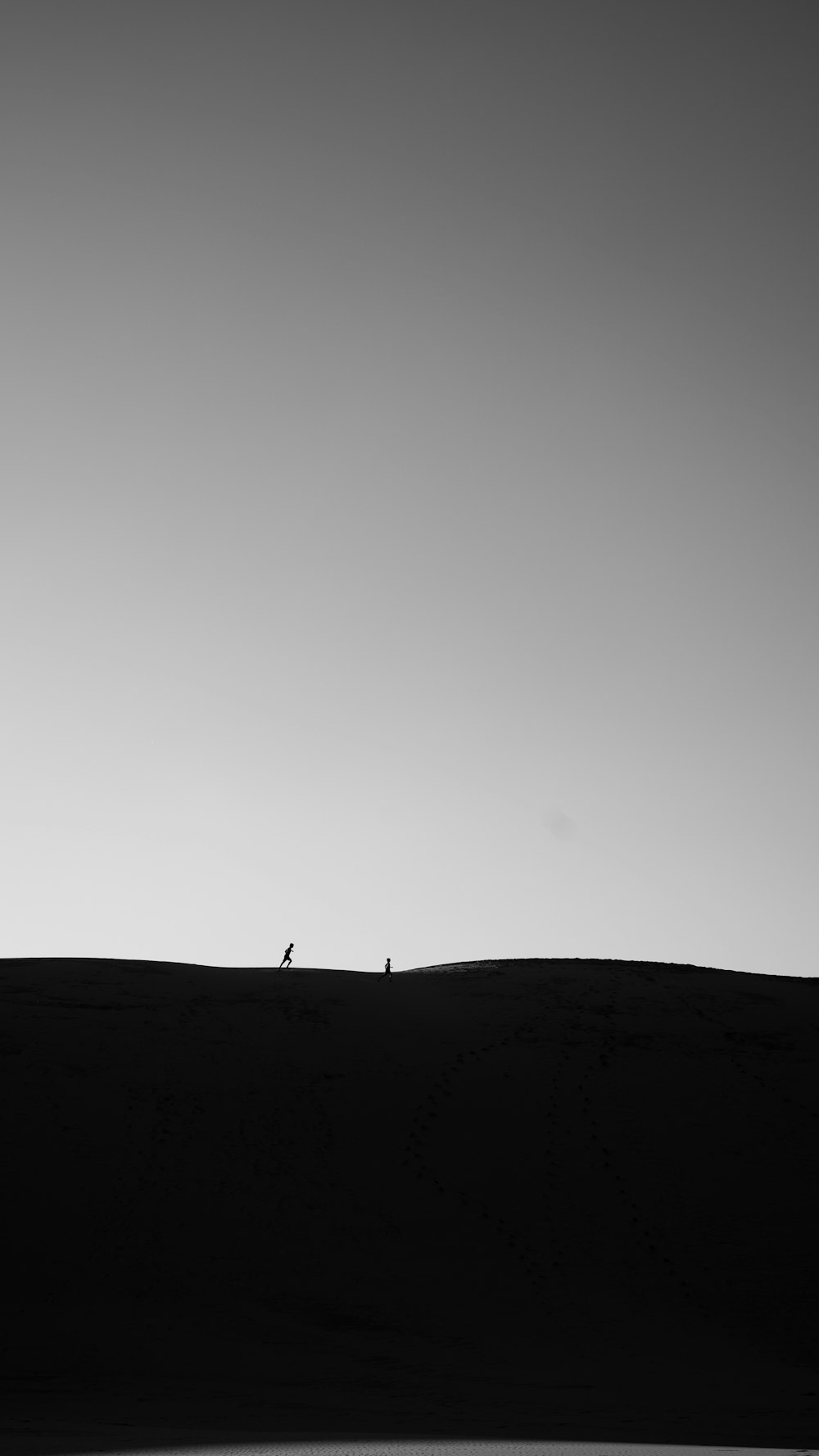 a couple of people standing on top of a hill