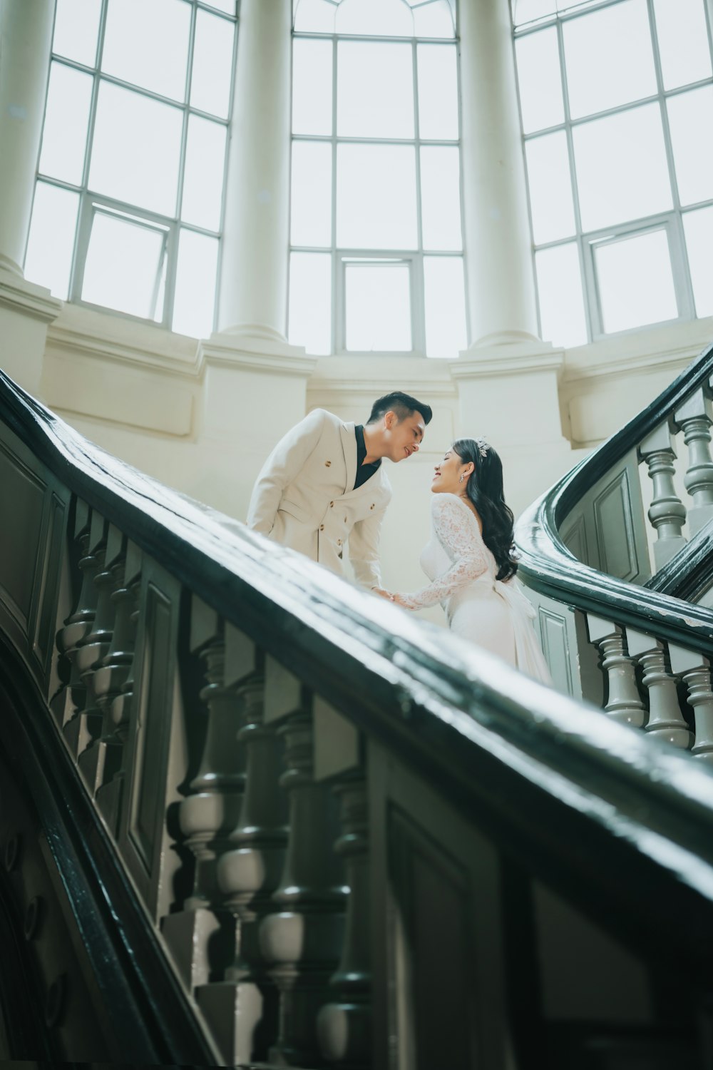 a bride and groom standing on the stairs of a building