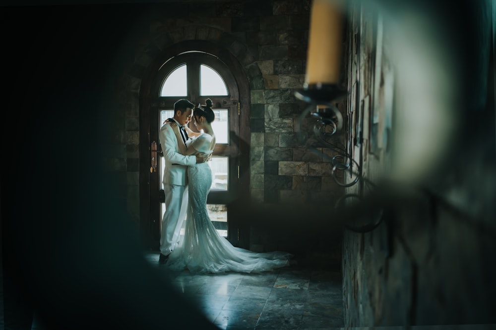 a bride and groom standing in front of a doorway