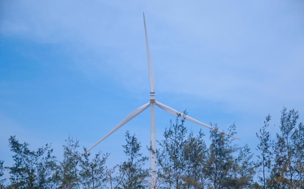 a wind turbine is seen through the trees