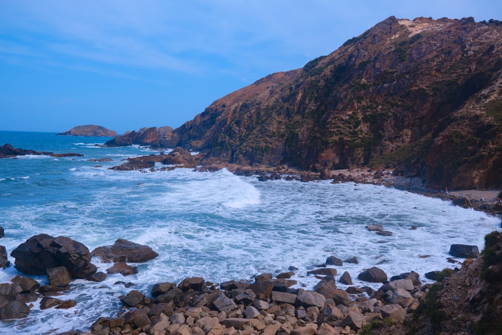 a rocky beach with a large body of water