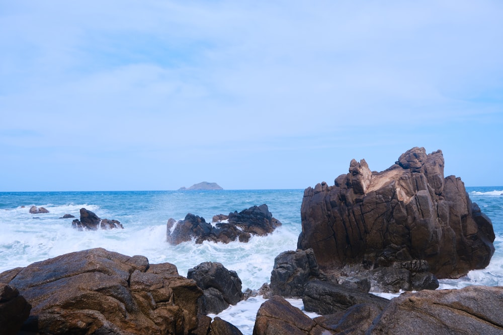 uma praia rochosa com ondas batendo contra as rochas