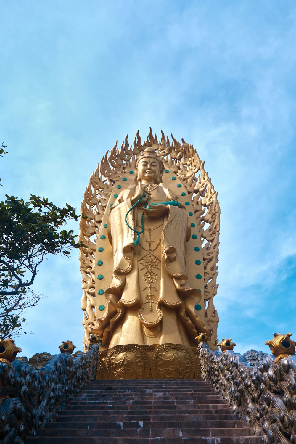 uma grande estátua de buda dourado sentada no topo de um conjunto de degraus