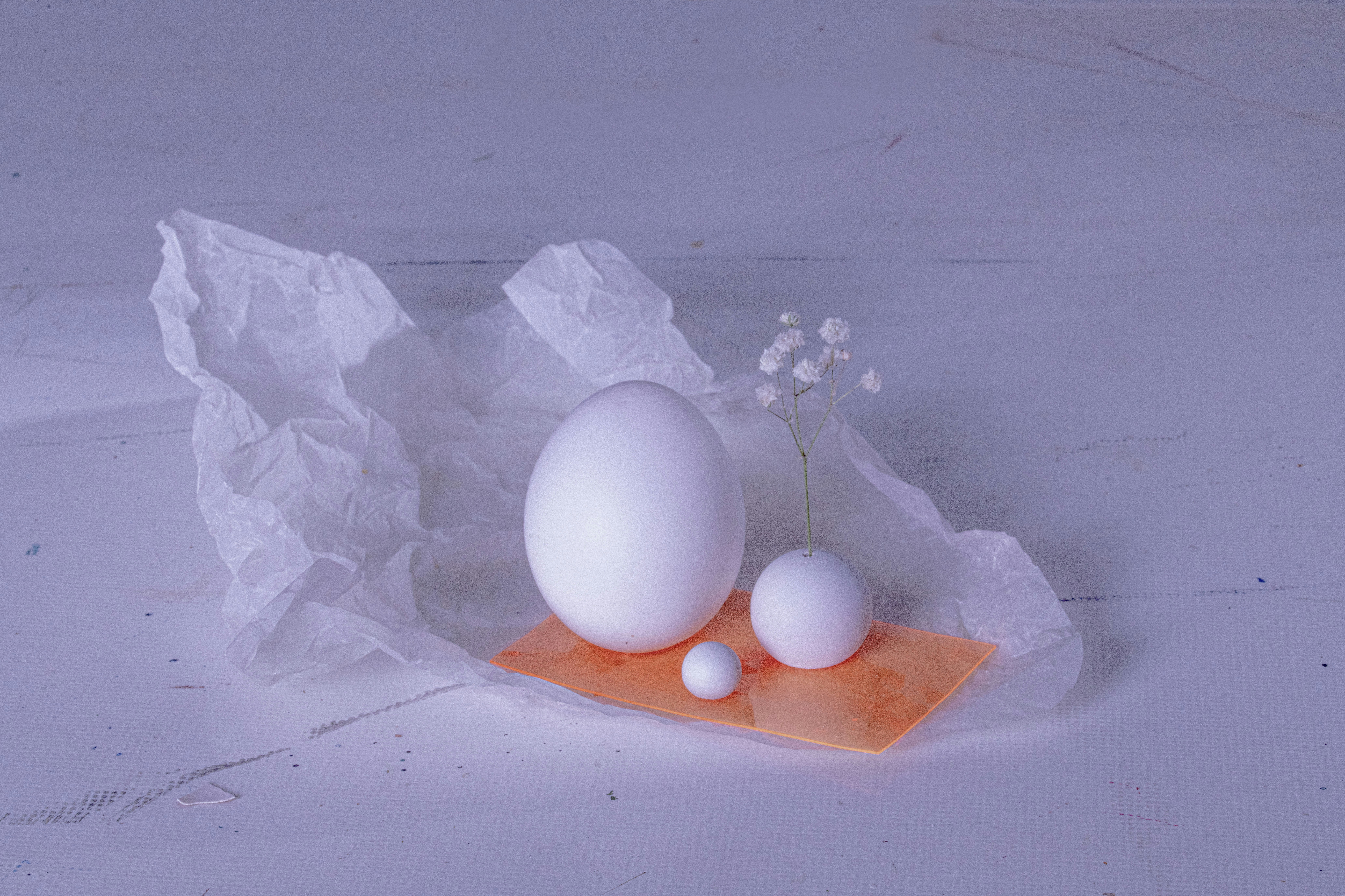 three white eggs sitting on top of a piece of paper