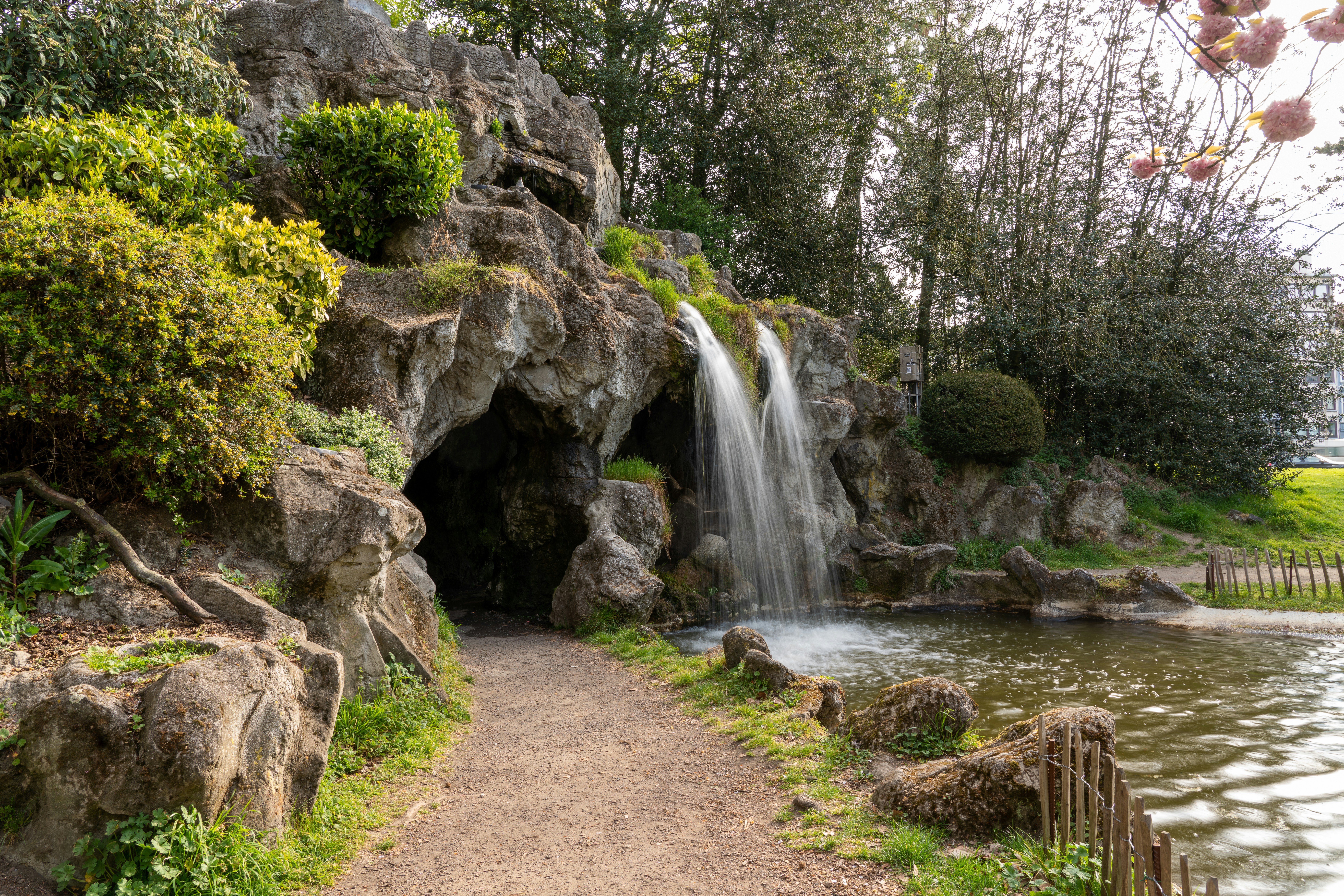 a small waterfall is coming out of a cave