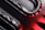 Curved metallic and glossy elements intertwine with smooth, reflective surfaces, displaying a sleek, high-tech appearance. The image incorporates sharp contrasts between dark and light sections, with striking red accents providing a bold visual impact.