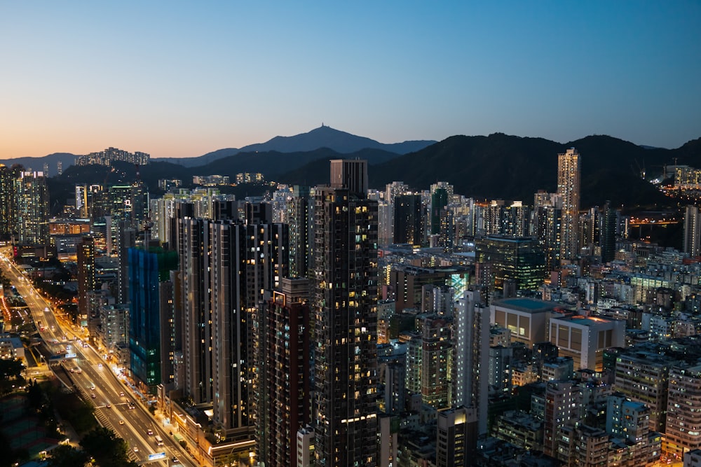 a view of a city at night with mountains in the background