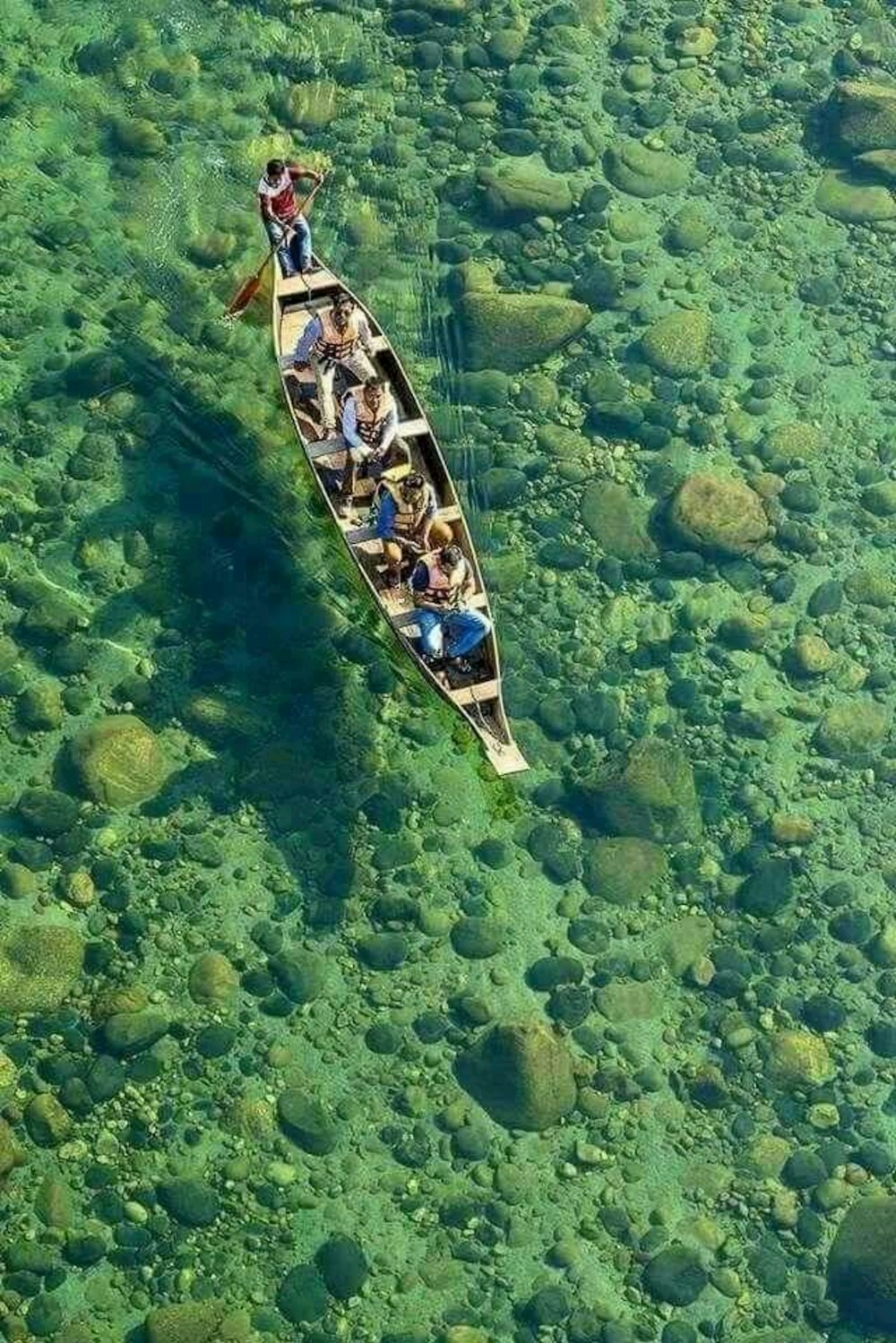 a group of people in a canoe floating on top of a body of water