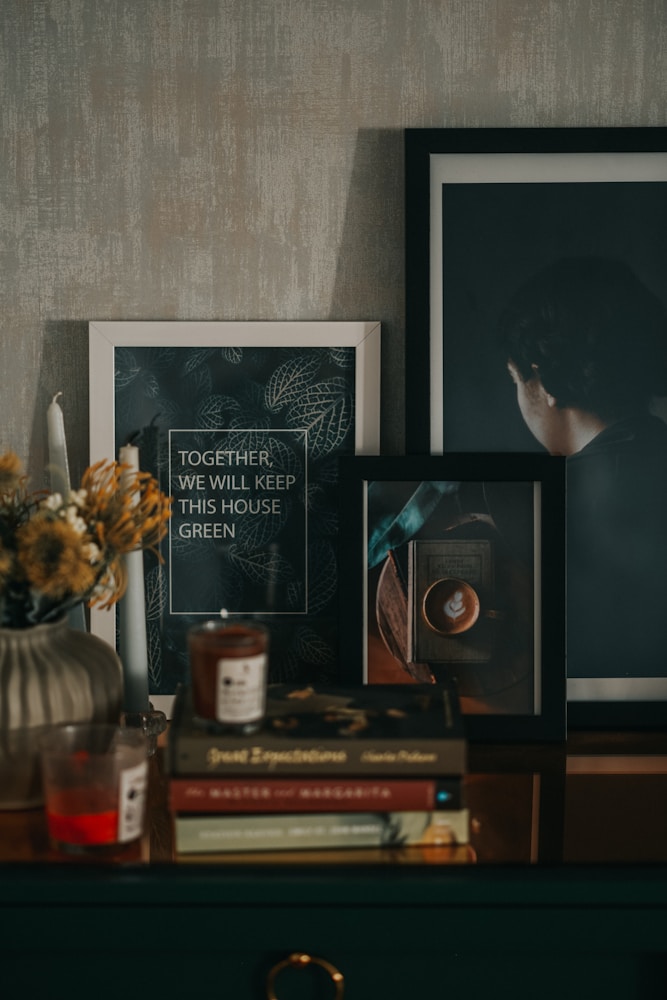 a table topped with pictures and a vase filled with flowers