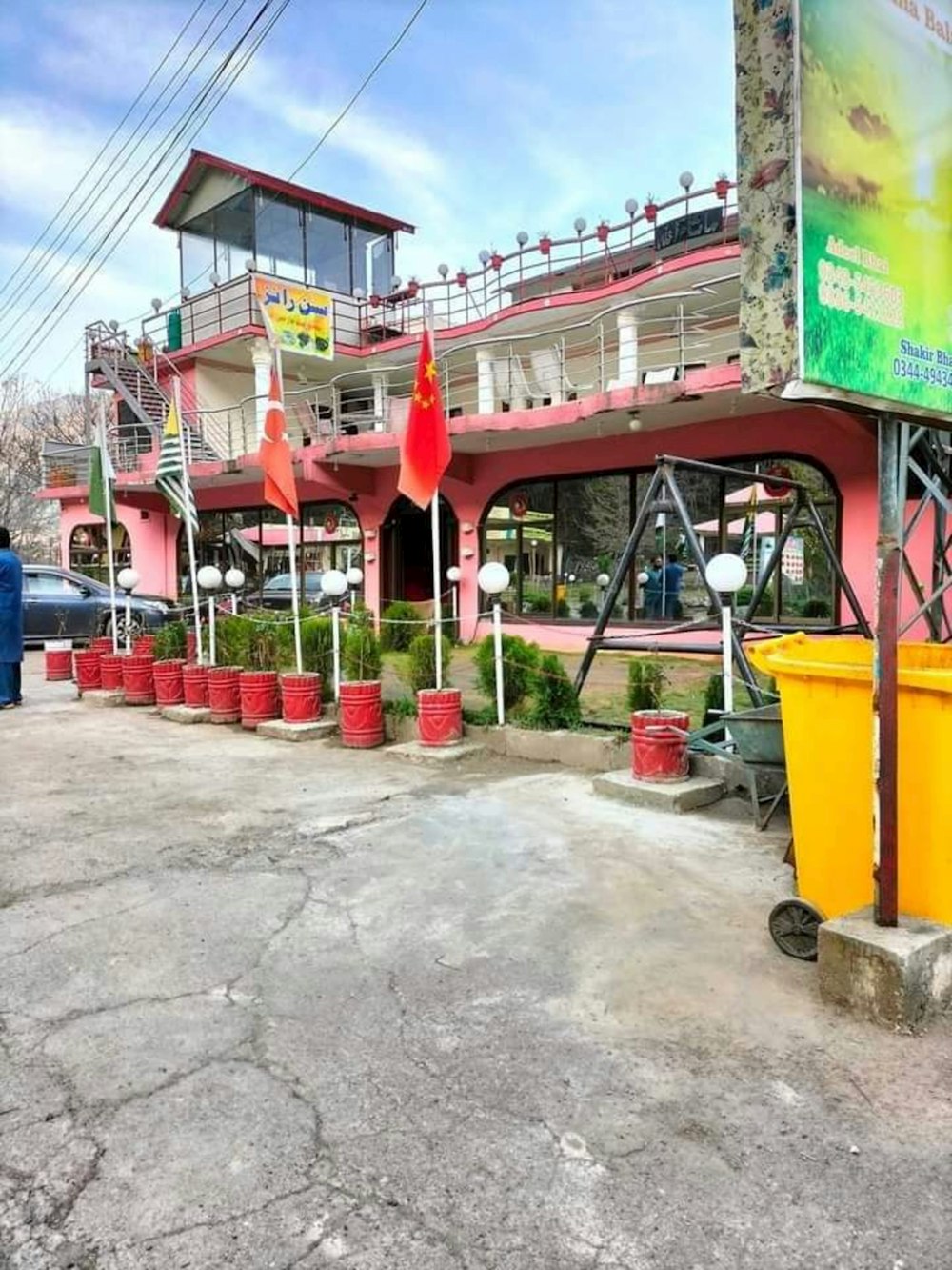 a red building with a yellow trash can in front of it