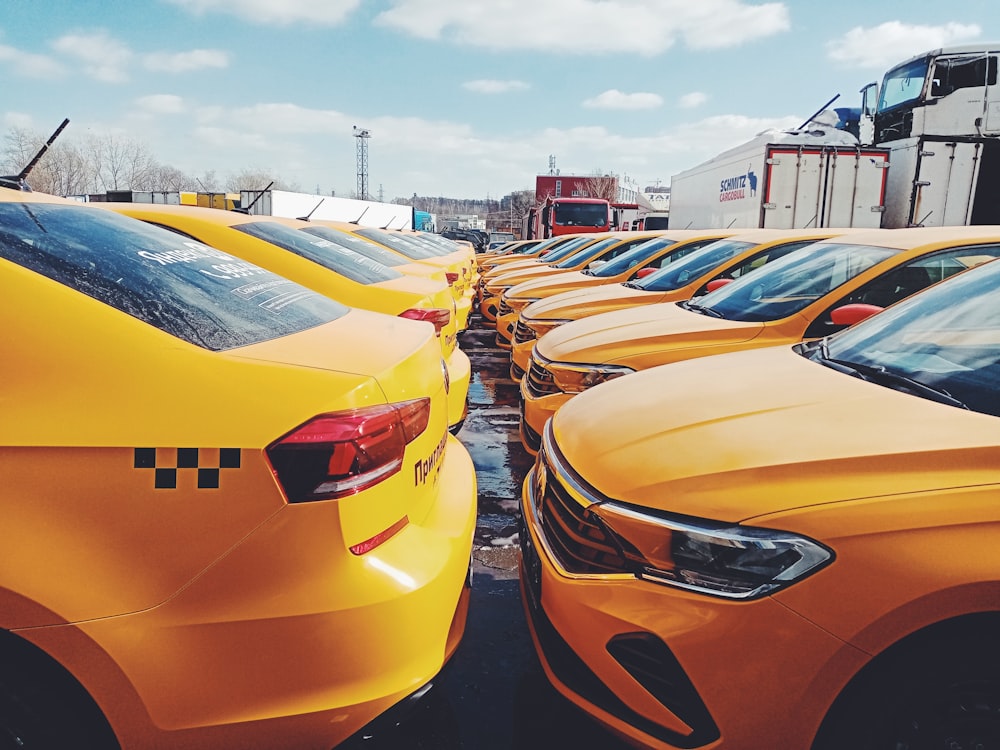 a row of yellow cars parked next to each other