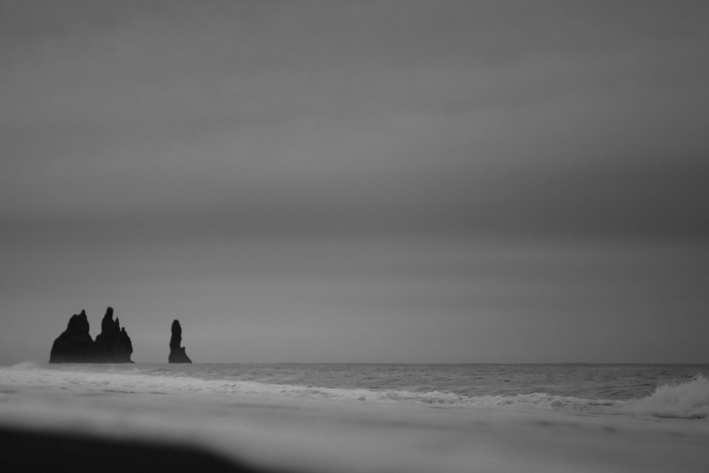 a black and white photo of some rocks in the water