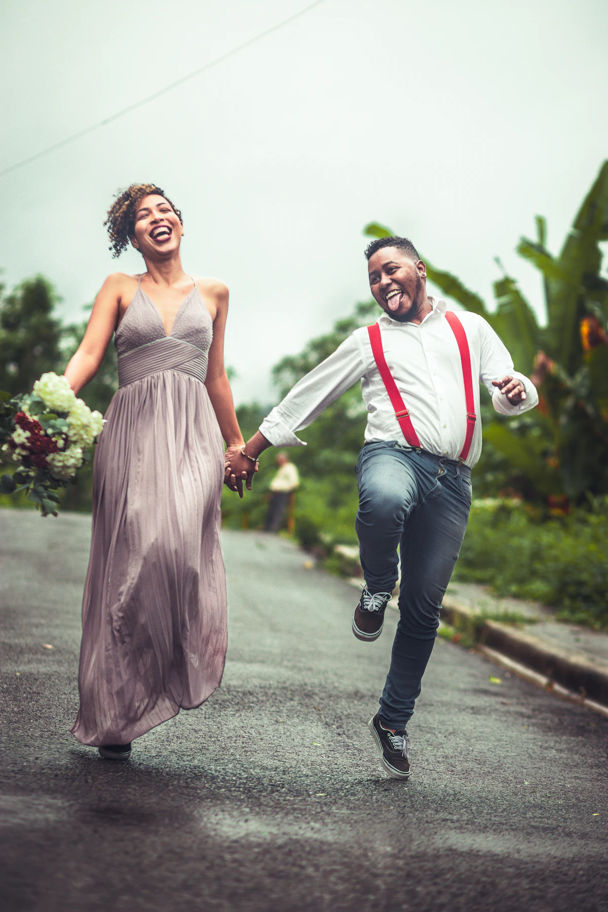 A man and a woman running and laughing down a street