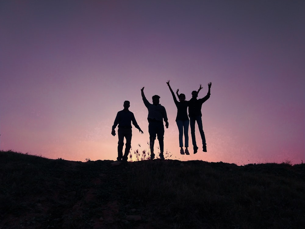 un groupe de personnes debout au sommet d’une colline