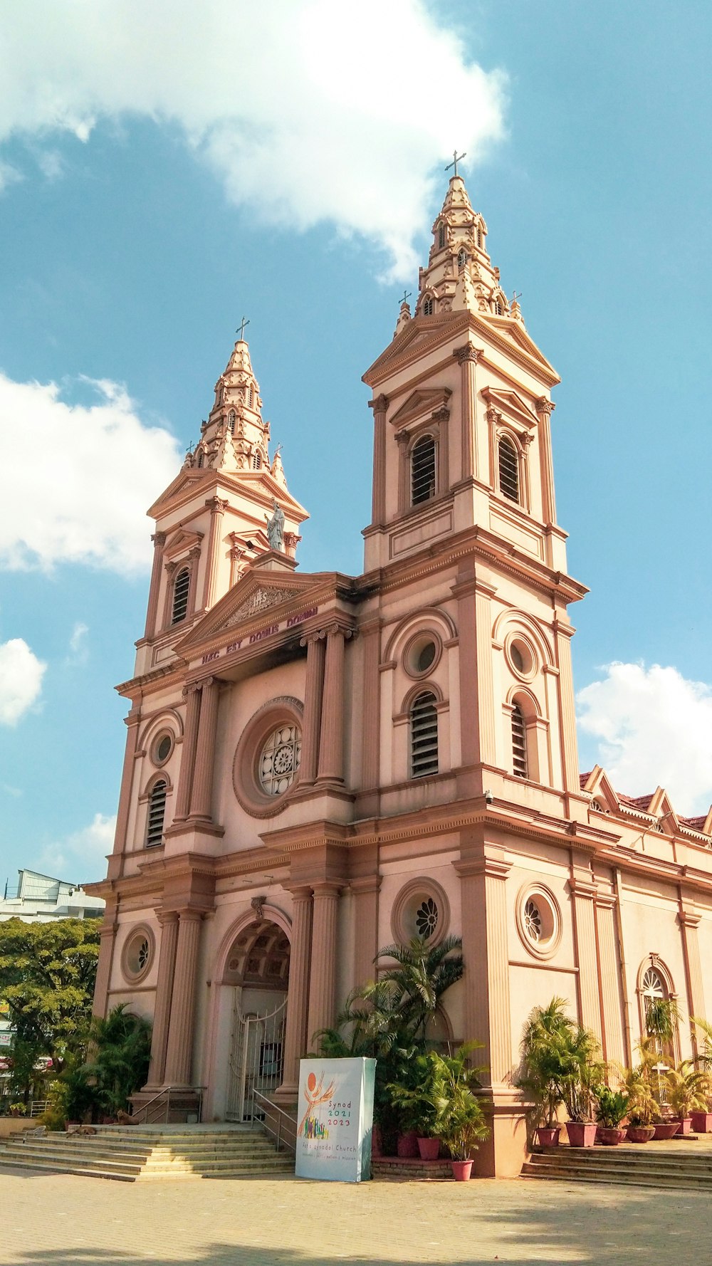 a large pink building with a clock on it's side