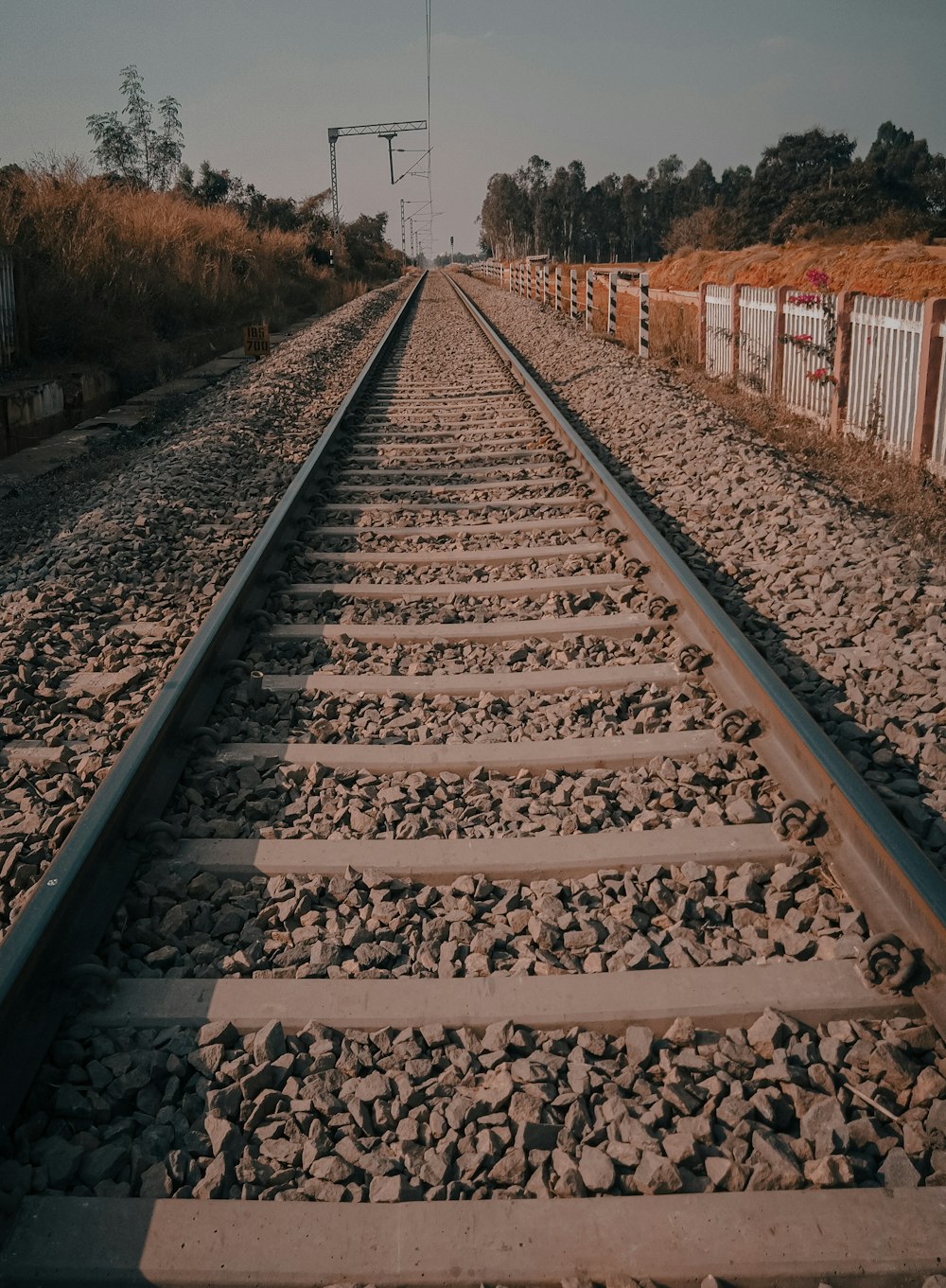 a train track with a fence in the background