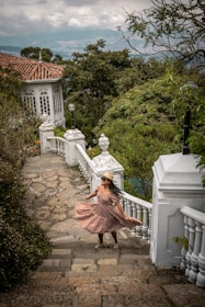 a woman in a dress is walking down a set of stairs