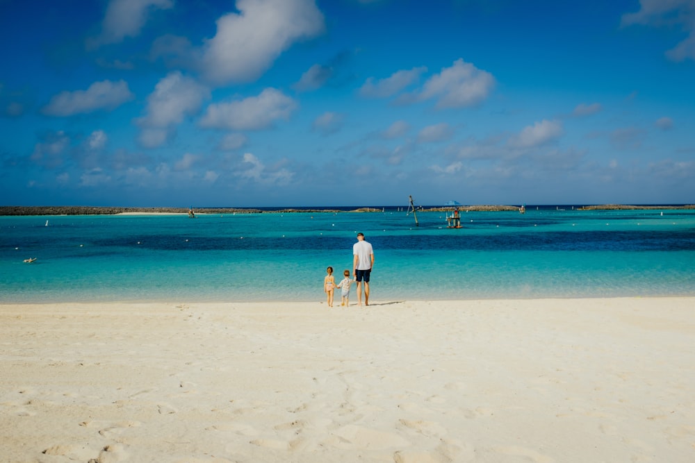 um homem e uma criança em pé em uma praia