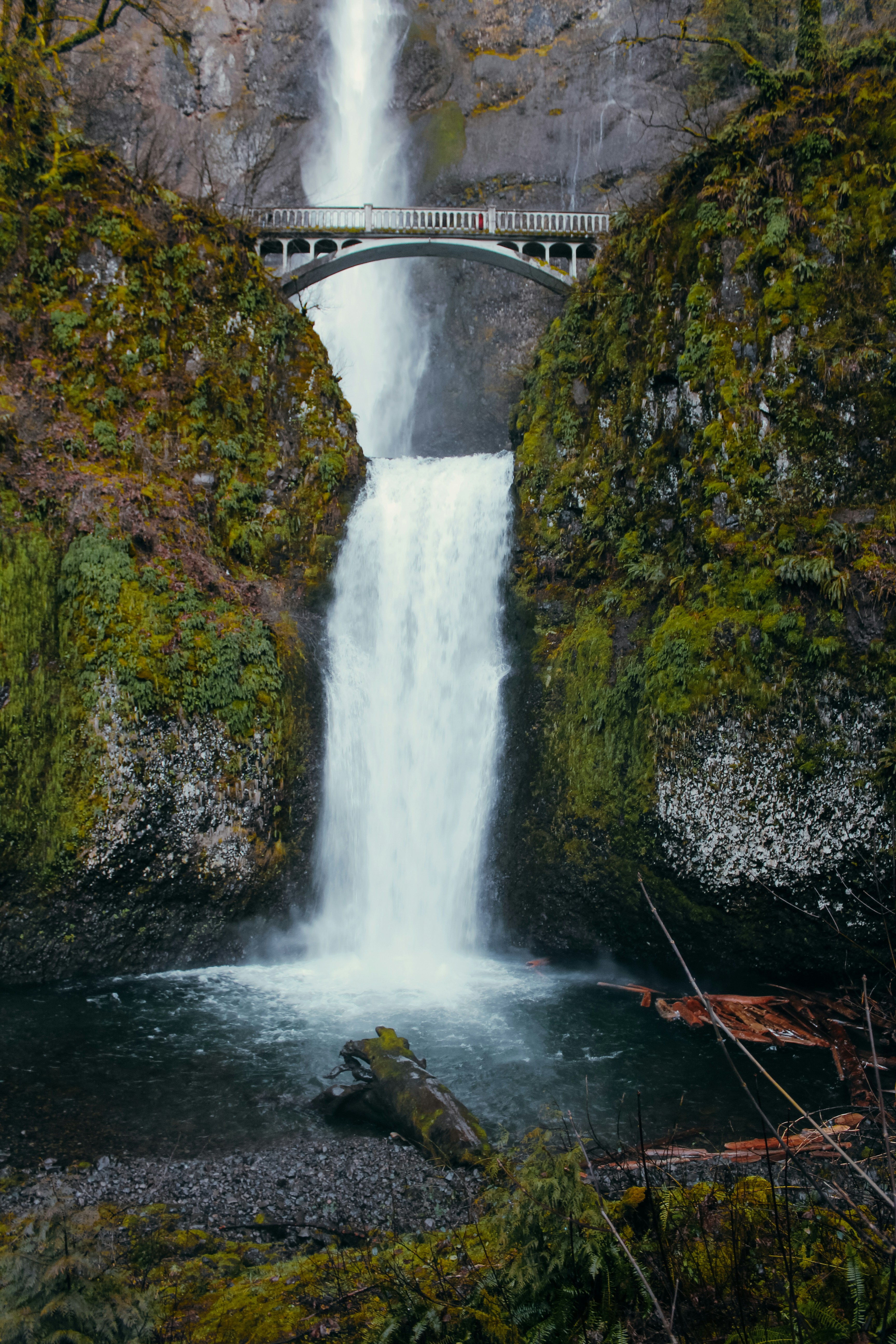 a large waterfall with a bridge over it