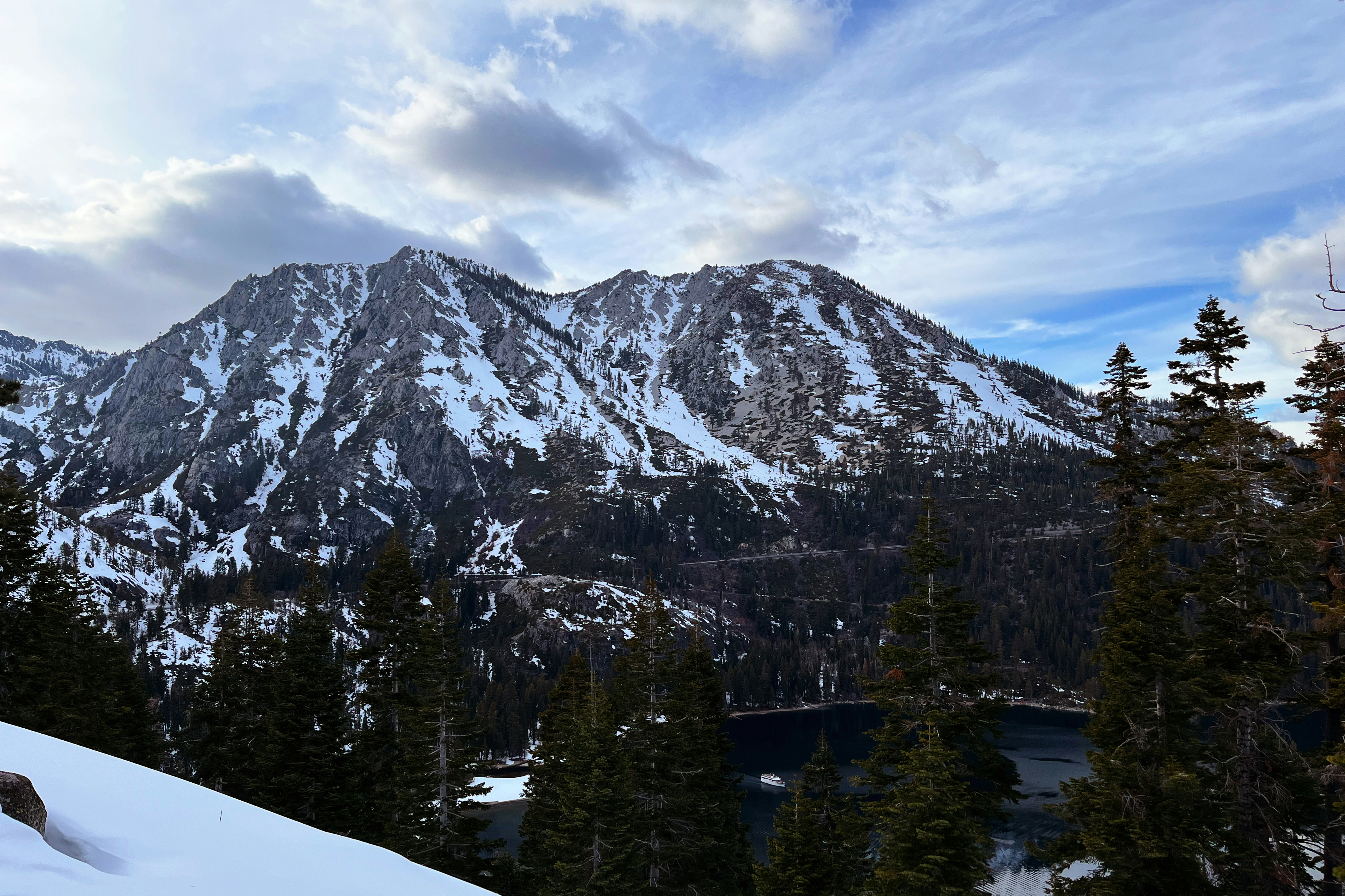 a snow covered mountain with a lake in the foreground