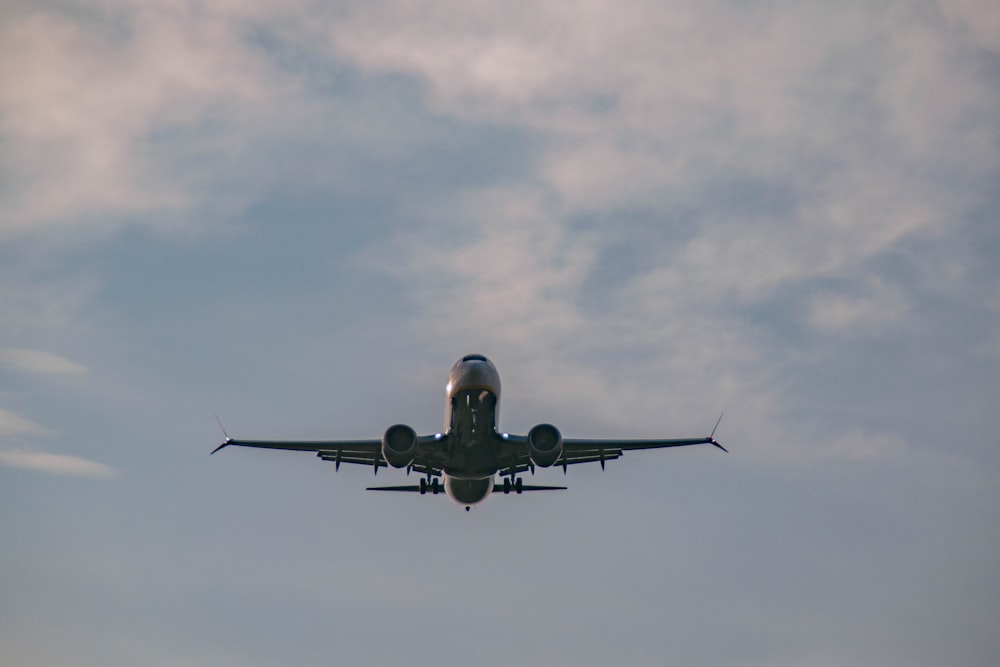 a large jetliner flying through a cloudy blue sky