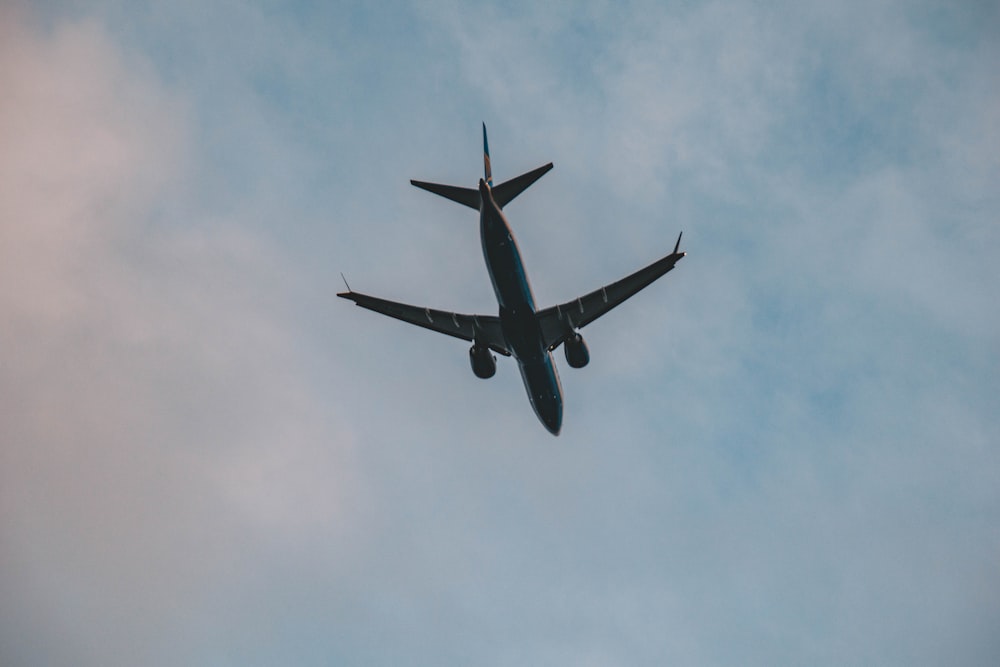 a large jetliner flying through a cloudy blue sky