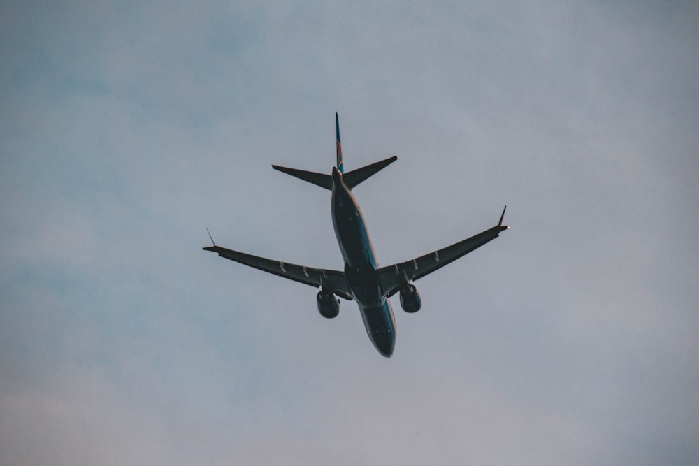 a large jetliner flying through a cloudy blue sky