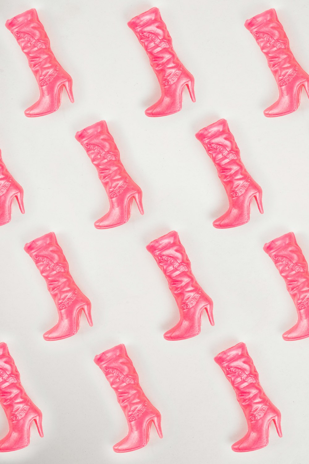 a bunch of pink boots that are on a table