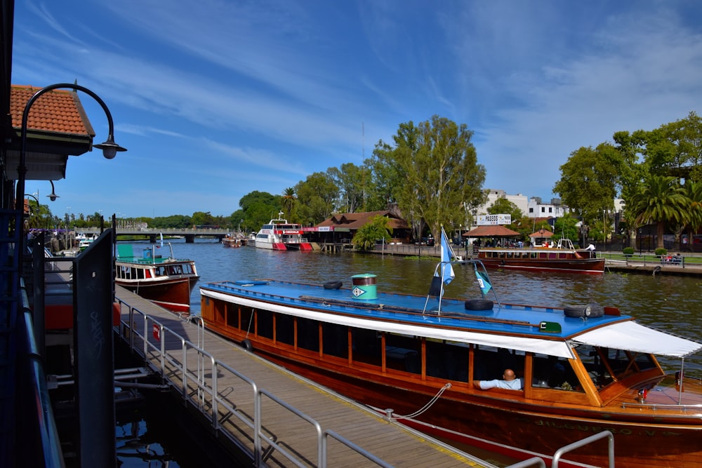 a blue and white boat docked at a pier